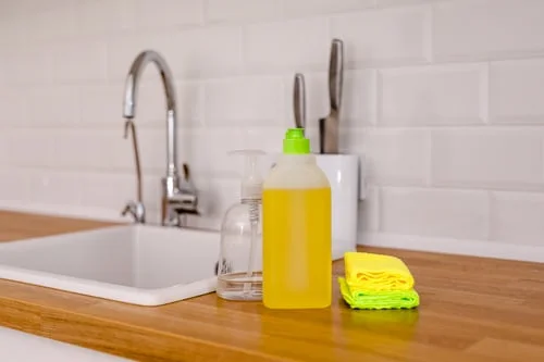 Clean white kitchen sink with dish soap and cloths after a New Jersey kitchen and bathroom cleaning service